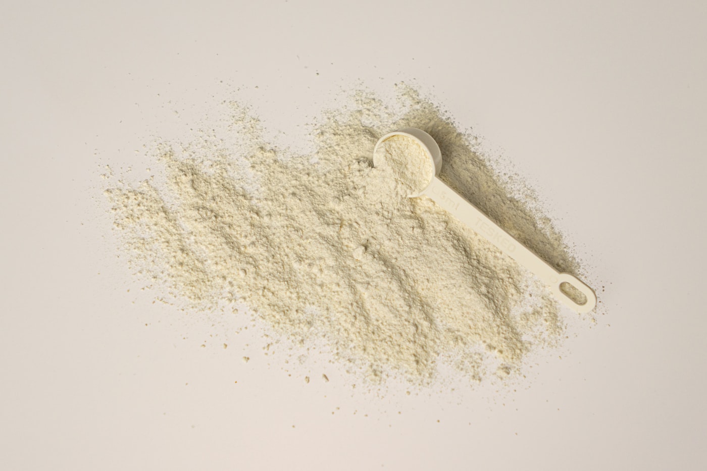 Dos porciones de proteína en polvo sobre fondo claro