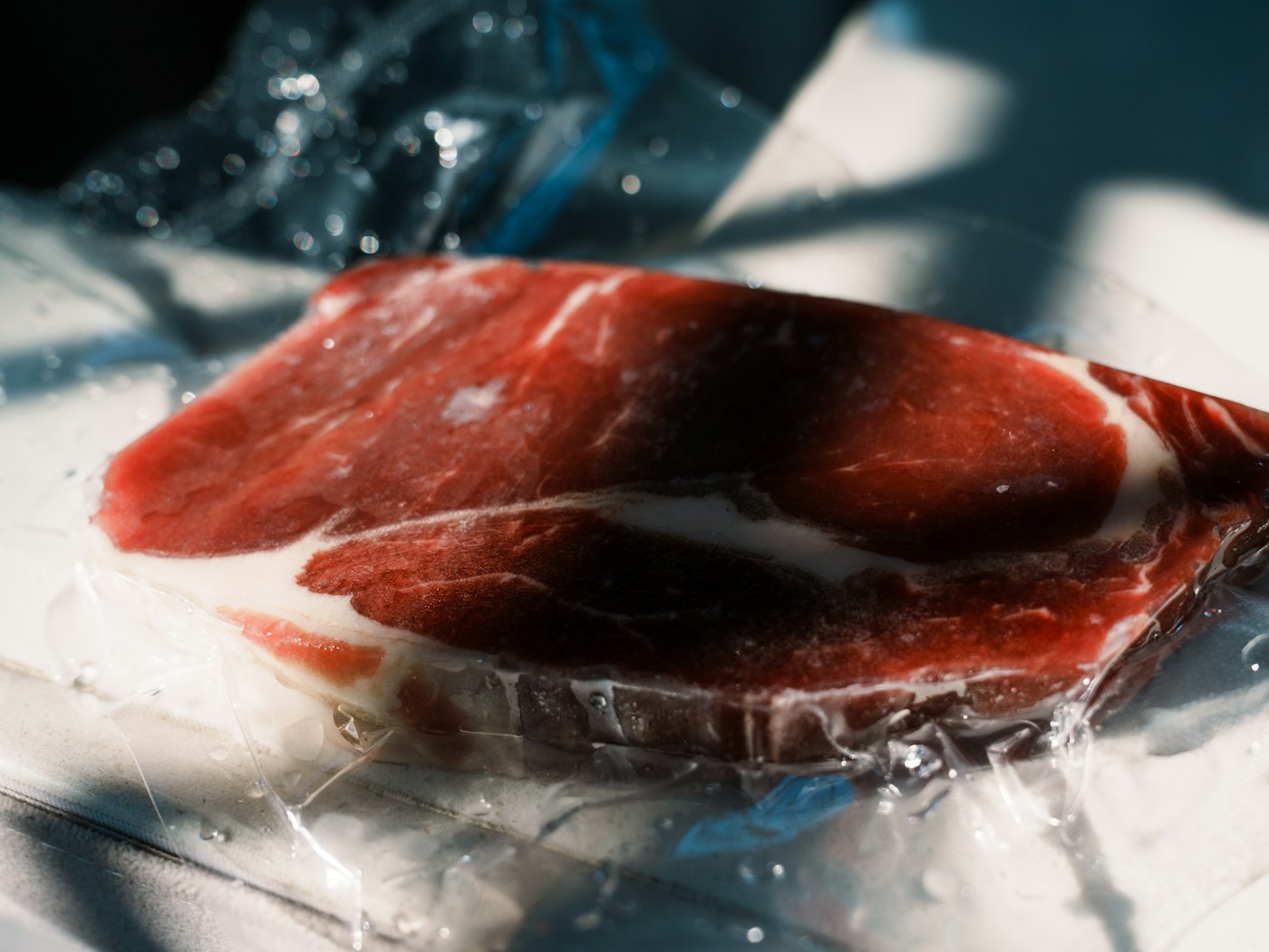 Corte de carne marmoleada empacado al vacío en película plástica