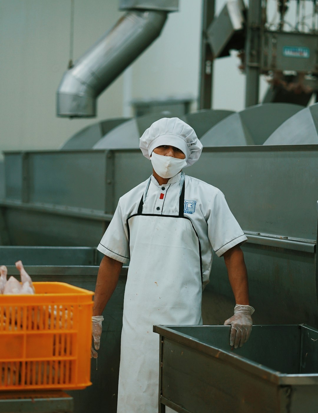 Operador con uniforme sanitario en una línea industrial de proceso de alimentos
